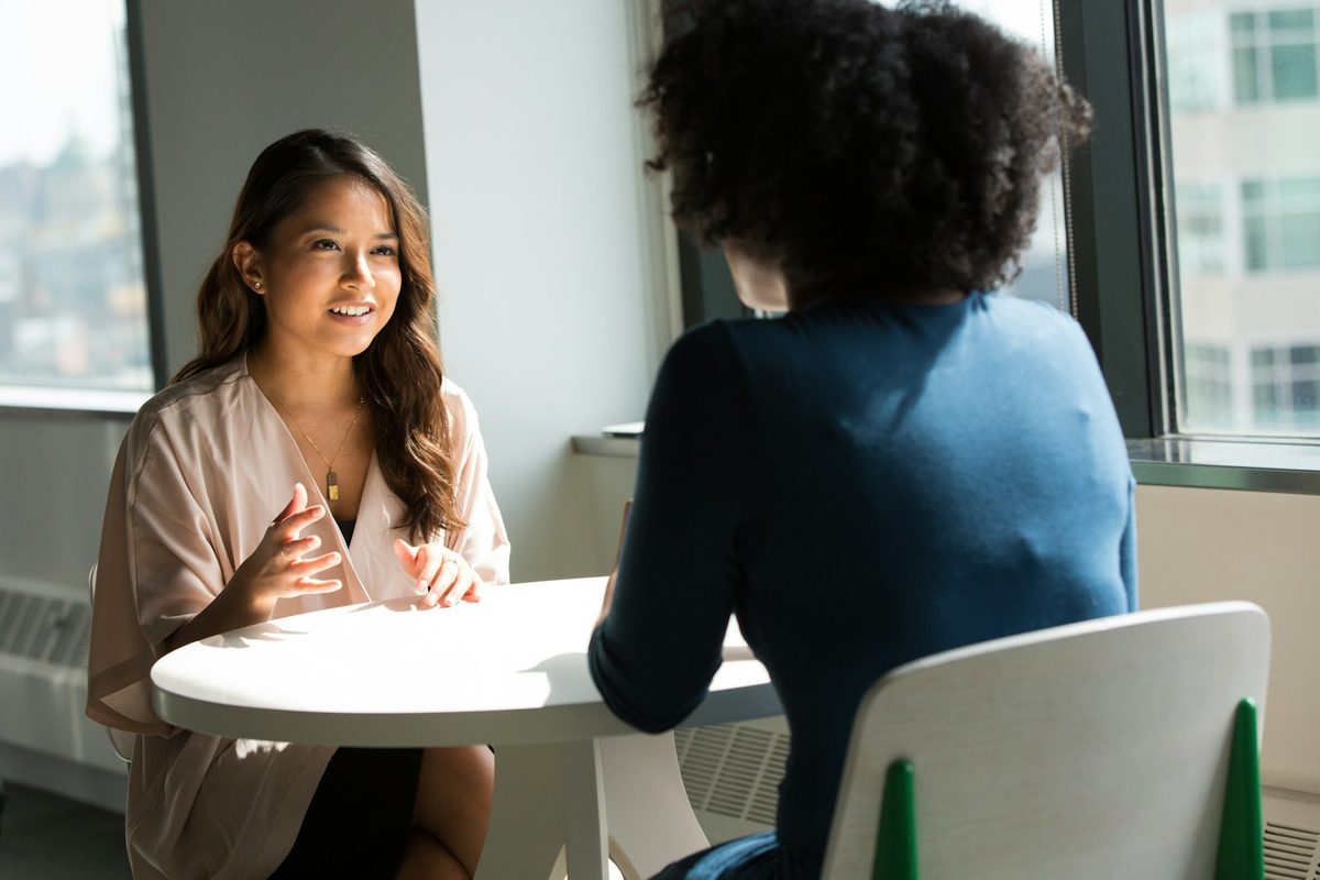 Duas mulheres conversando com calma em uma avaliação